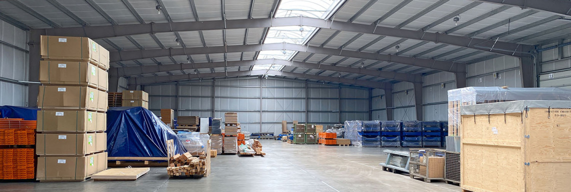 You can see into the depth of a newly built warehouse with different packed goods, on the right and left side of the picture.
