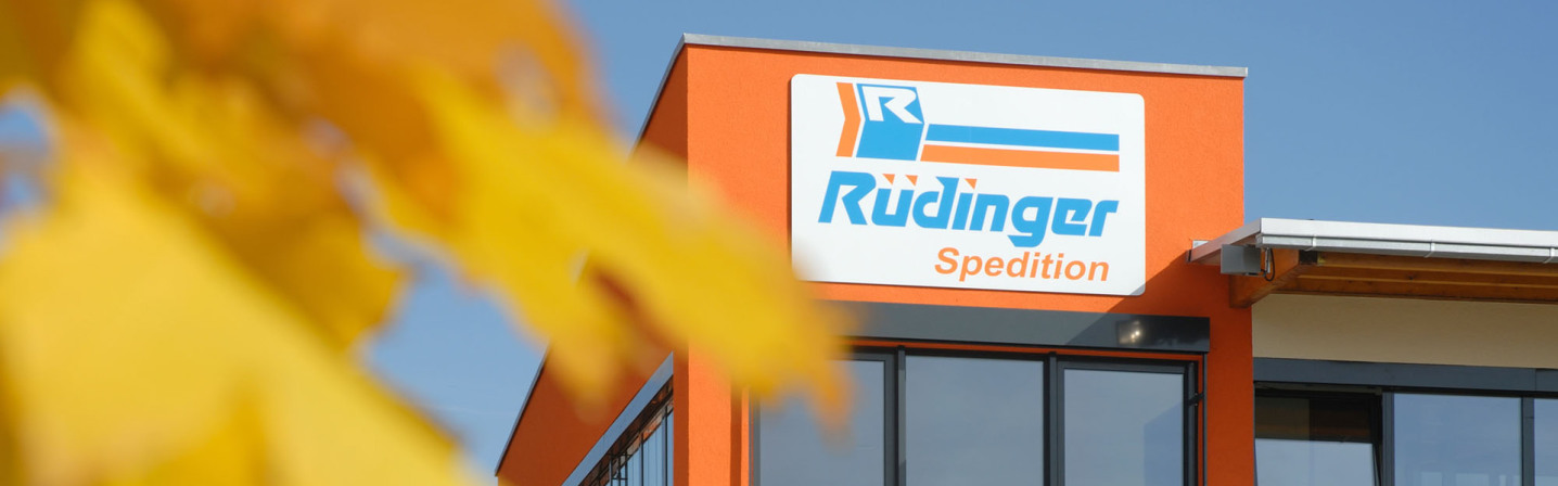 At the top of the new administration building of Rüdinger Freight Forwarder Germany. It is an orange facade and on it is a huge sign, in German it is "Rüdinger Spedition".