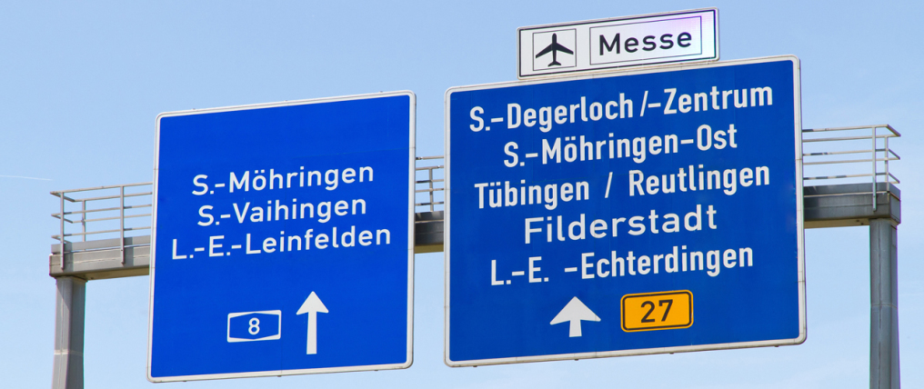 It is a dark blue traffic sign to Frankfurt Airport and other destinations. It is a sign bridge in front of blue sky.