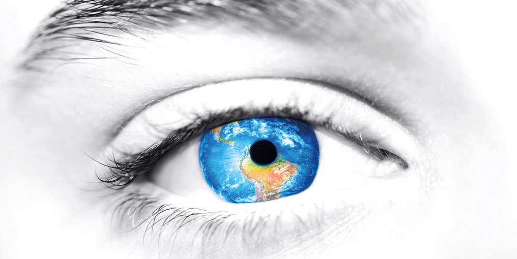 A gigantic eye looks at the viewer. In the center the eyeball is a blue globe and in the lower part you can see Africa. In the middle is the black pupil.